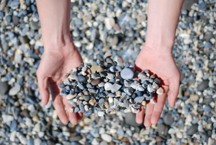 a pair of hands holding small gravel and stones | Aggregate Express